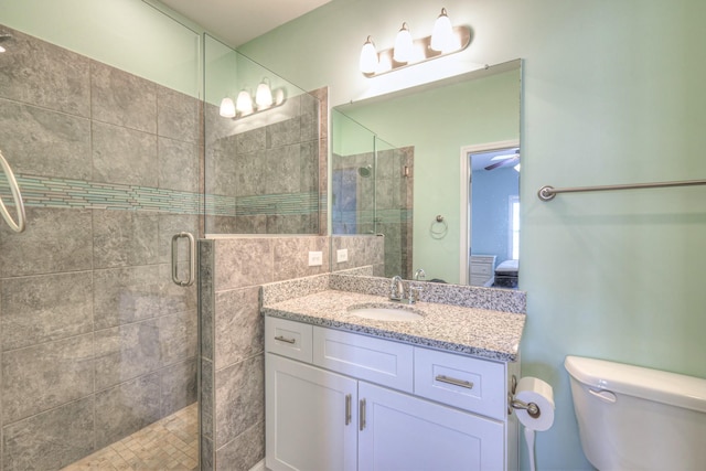 bathroom with vanity, toilet, and a shower stall