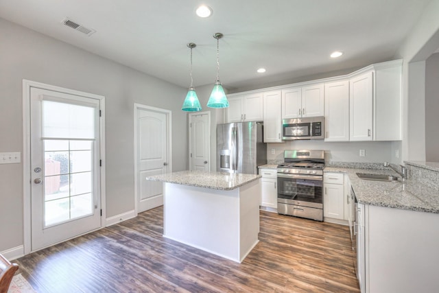 kitchen with visible vents, dark wood finished floors, stainless steel appliances, white cabinetry, and a sink