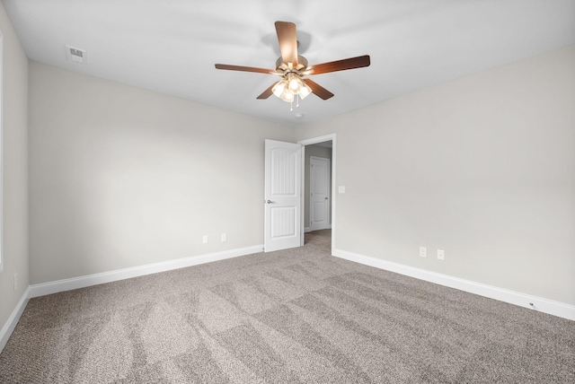 carpeted empty room featuring visible vents, a ceiling fan, and baseboards