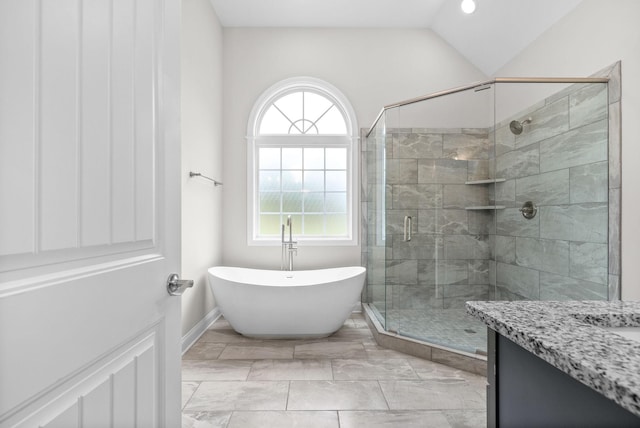 full bath featuring vanity, a shower stall, a soaking tub, and vaulted ceiling