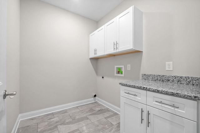 washroom with cabinet space, hookup for an electric dryer, hookup for a washing machine, and baseboards