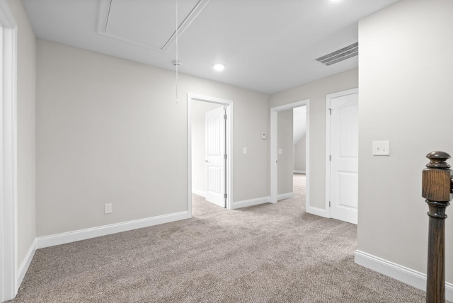 carpeted empty room featuring recessed lighting, visible vents, baseboards, and attic access