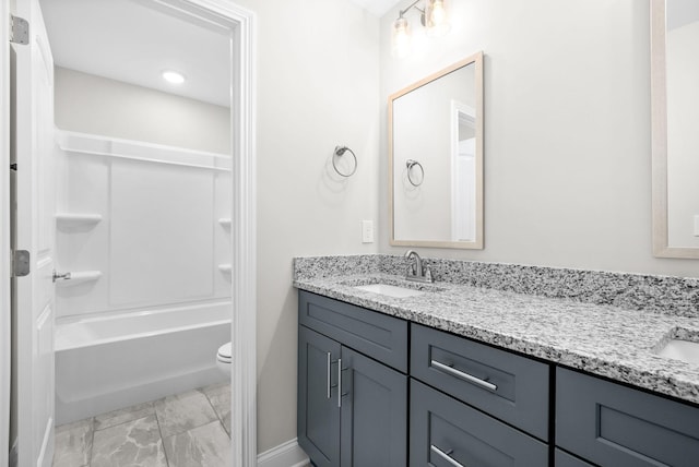 bathroom featuring double vanity, toilet, shower / washtub combination, and a sink