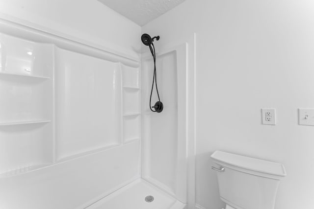 full bathroom with toilet, walk in shower, and a textured ceiling