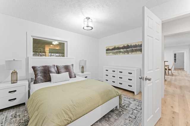 bedroom with a textured ceiling and light wood-style flooring