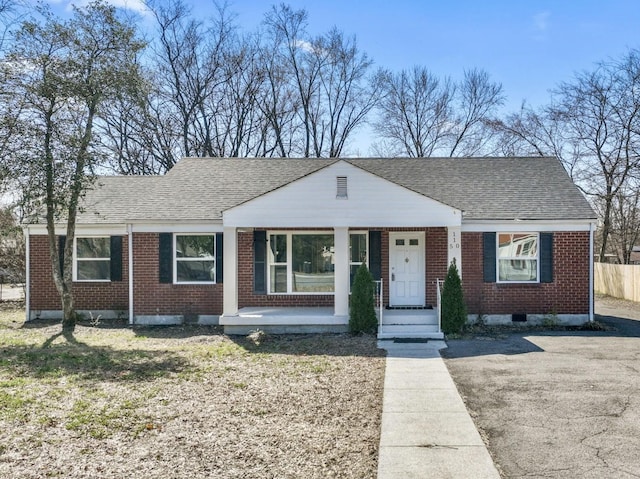 bungalow-style home featuring brick siding, roof with shingles, and fence