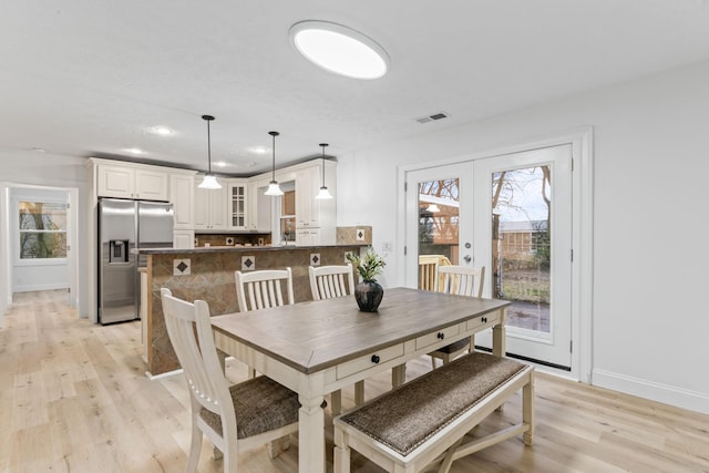 dining area featuring visible vents, plenty of natural light, french doors, and light wood-style flooring