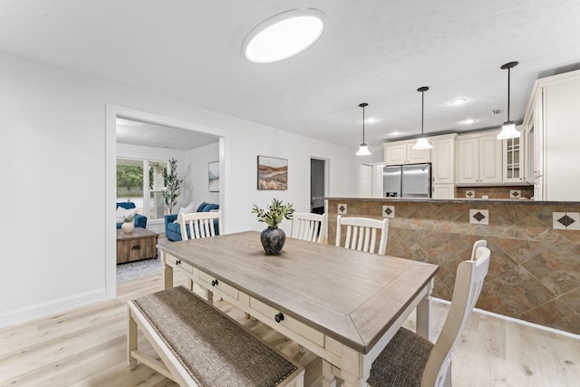 dining room featuring light wood-style floors and baseboards