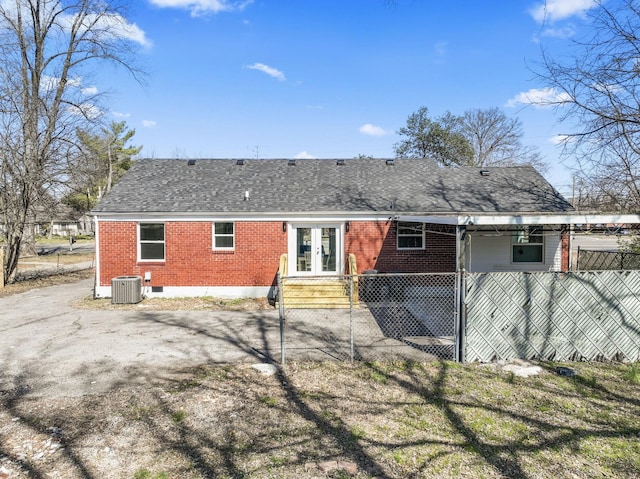 back of property featuring brick siding, cooling unit, french doors, and roof with shingles