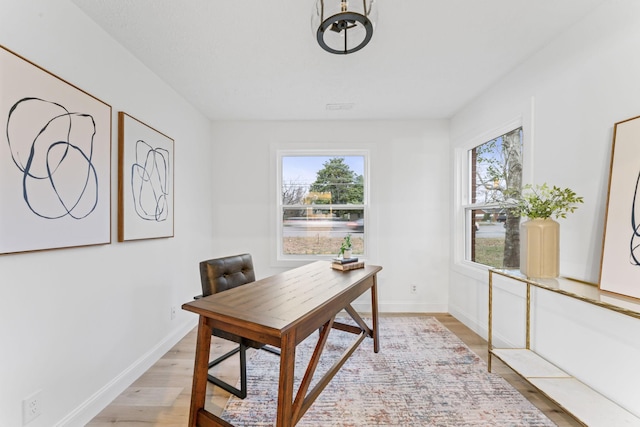 office with light wood finished floors, plenty of natural light, and baseboards