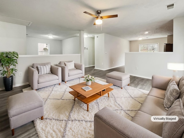 living room featuring visible vents, ceiling fan, baseboards, and wood finished floors