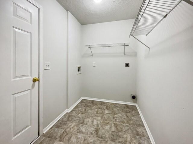 clothes washing area featuring baseboards, laundry area, hookup for a washing machine, electric dryer hookup, and a textured ceiling