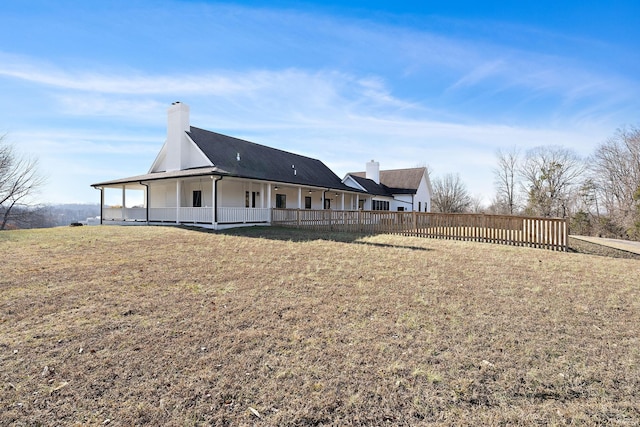 rear view of property with a lawn and a chimney