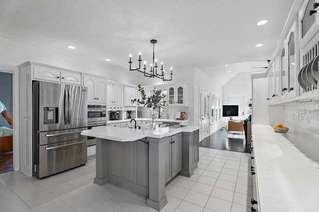 kitchen featuring light countertops, white cabinets, light tile patterned flooring, and stainless steel fridge