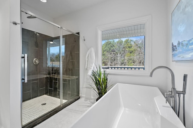 bathroom featuring a freestanding tub and a shower stall