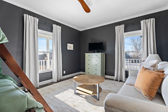 living room featuring wood finished floors, baseboards, ornamental molding, and ceiling fan