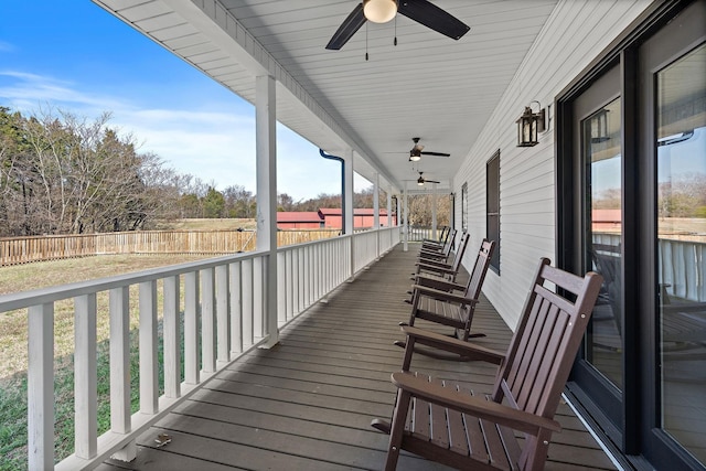 wooden deck with a porch, ceiling fan, and fence