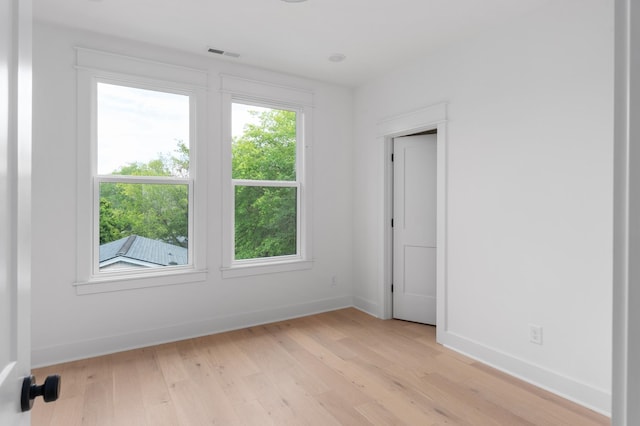 unfurnished room featuring visible vents, baseboards, and light wood-style flooring