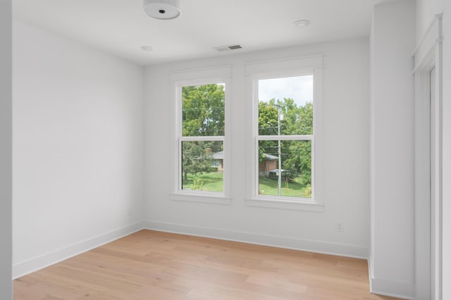 spare room with light wood-style flooring, plenty of natural light, and baseboards