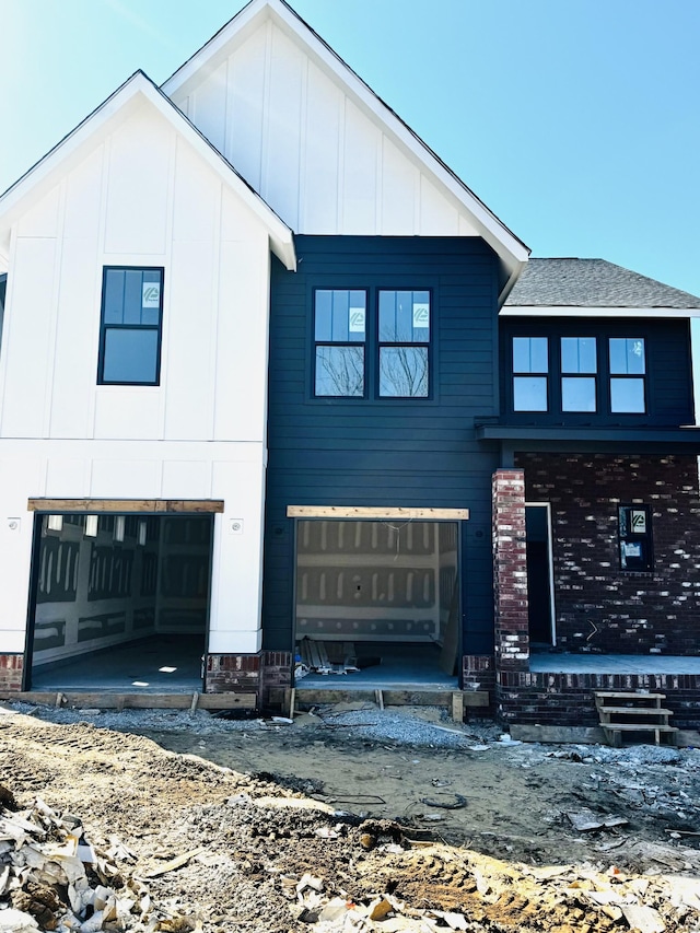 view of front of home with board and batten siding and a shingled roof