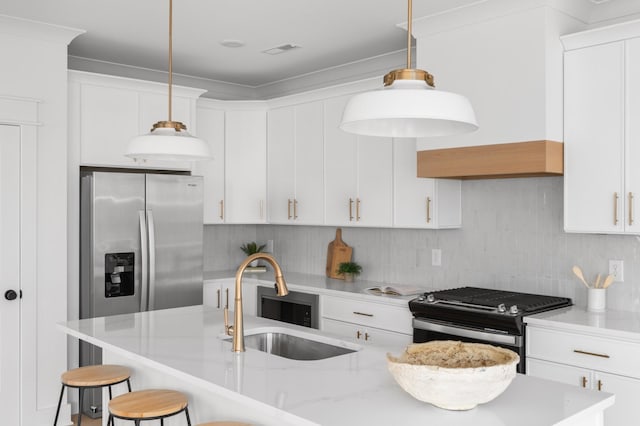 kitchen with visible vents, a sink, backsplash, appliances with stainless steel finishes, and a breakfast bar area