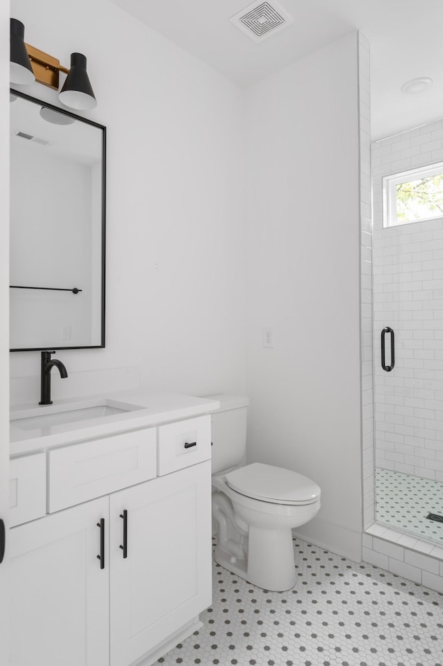 full bathroom featuring visible vents, a shower stall, toilet, and vanity