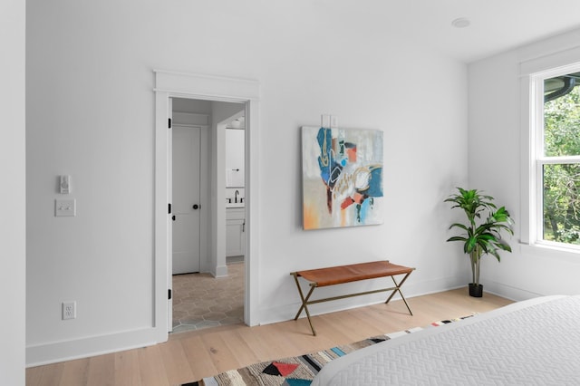 bedroom featuring a sink, baseboards, and wood finished floors