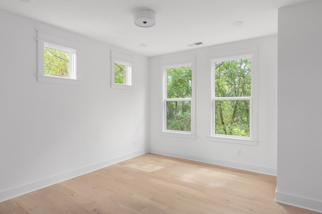 spare room with light wood-type flooring, baseboards, and visible vents