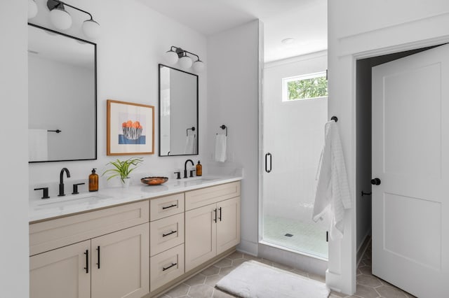 bathroom with a sink, a stall shower, double vanity, and tile patterned flooring