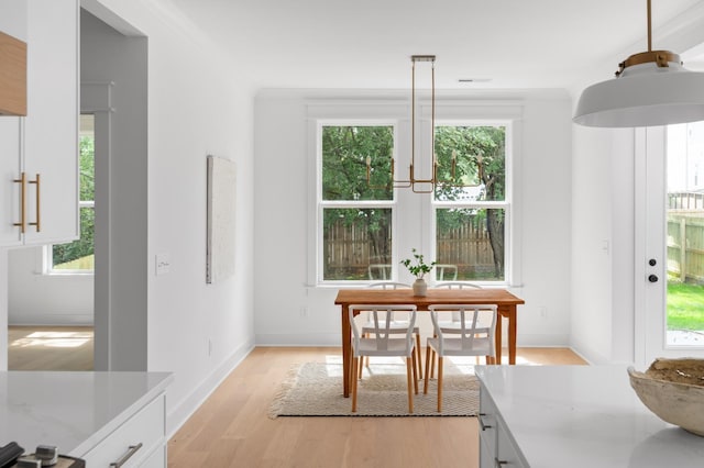 dining room featuring visible vents, baseboards, and light wood finished floors