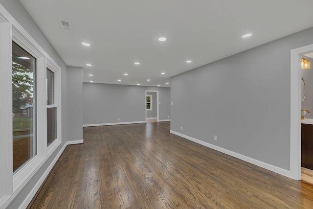 unfurnished living room featuring visible vents, recessed lighting, dark wood-type flooring, and baseboards