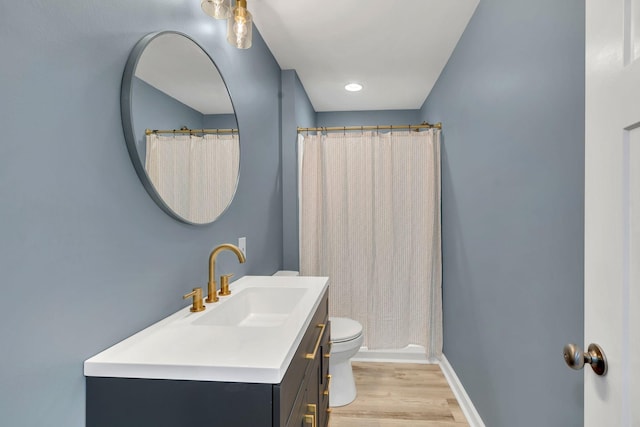 bathroom with vanity, a shower with shower curtain, wood finished floors, baseboards, and toilet