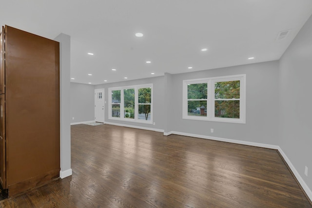 unfurnished living room with dark wood finished floors, visible vents, recessed lighting, and baseboards