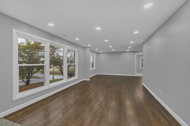 unfurnished living room featuring visible vents, recessed lighting, dark wood-type flooring, and baseboards