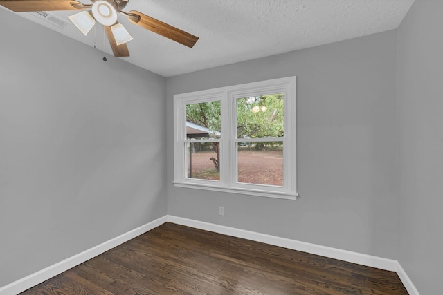 unfurnished room with a textured ceiling, dark wood-type flooring, baseboards, and a ceiling fan