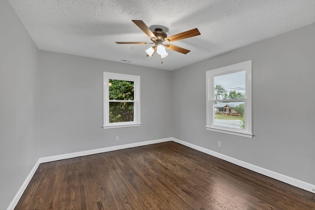 unfurnished room with baseboards, dark wood-type flooring, and a textured ceiling