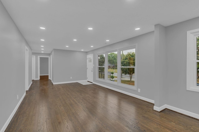 unfurnished living room with recessed lighting, baseboards, and dark wood-style flooring