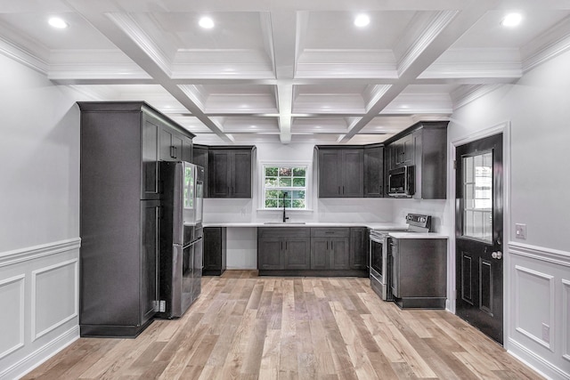 kitchen with beamed ceiling, light wood finished floors, coffered ceiling, appliances with stainless steel finishes, and light countertops