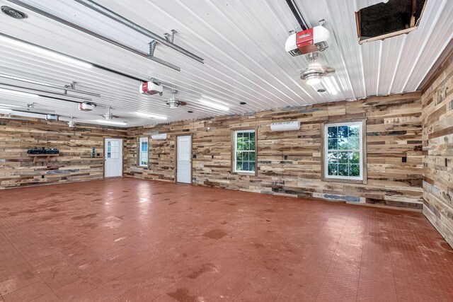 garage with wooden walls, a garage door opener, and a wall mounted air conditioner