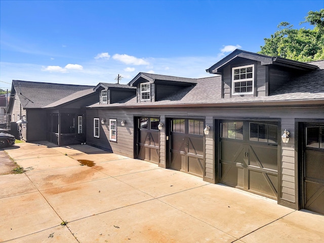 view of front of property with concrete driveway and a shingled roof