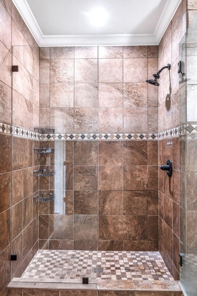 bathroom featuring crown molding and a stall shower