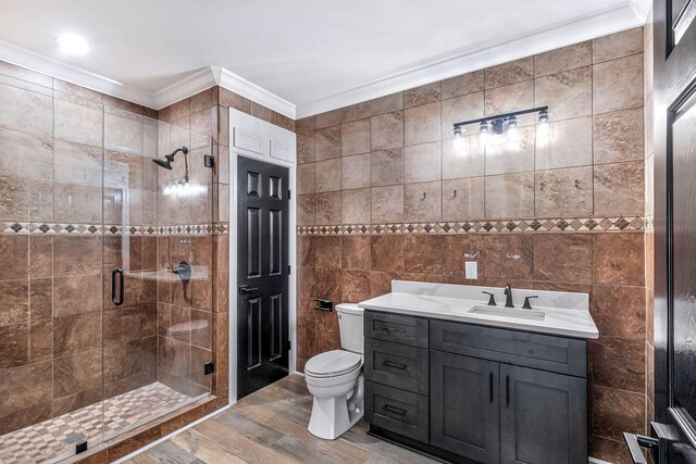 bathroom with vanity, ornamental molding, a shower stall, tile walls, and toilet