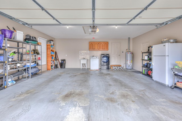 garage with gas water heater, a garage door opener, freestanding refrigerator, and a sink