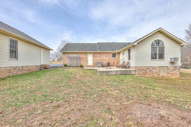 rear view of property featuring a wall unit AC, a yard, and a patio area