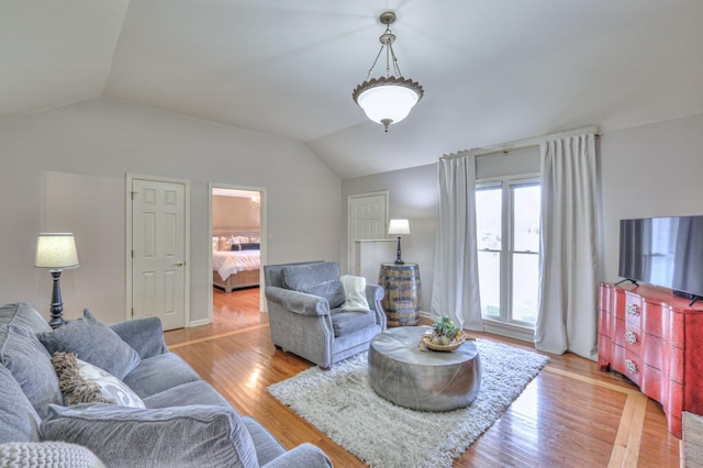 living area featuring lofted ceiling and light wood finished floors