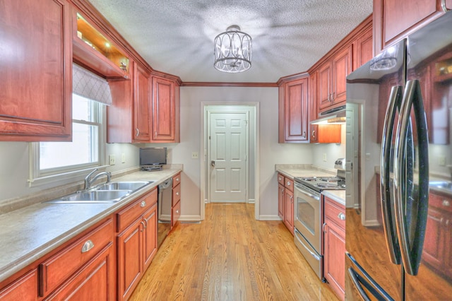 kitchen featuring under cabinet range hood, dishwasher, stainless steel range with electric stovetop, freestanding refrigerator, and a sink