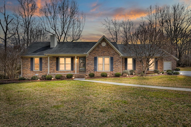 ranch-style home with a front lawn, concrete driveway, a garage, brick siding, and a chimney