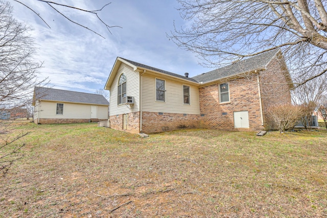 back of house with crawl space and a lawn