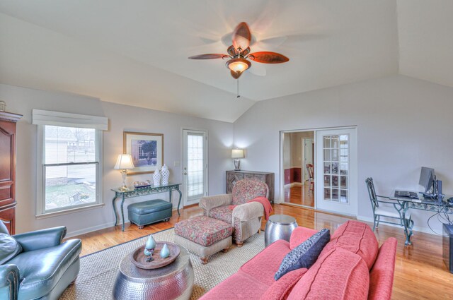 living area featuring plenty of natural light, wood finished floors, and vaulted ceiling