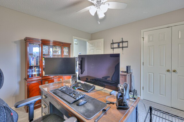 office area featuring a textured ceiling, ceiling fan, and carpet